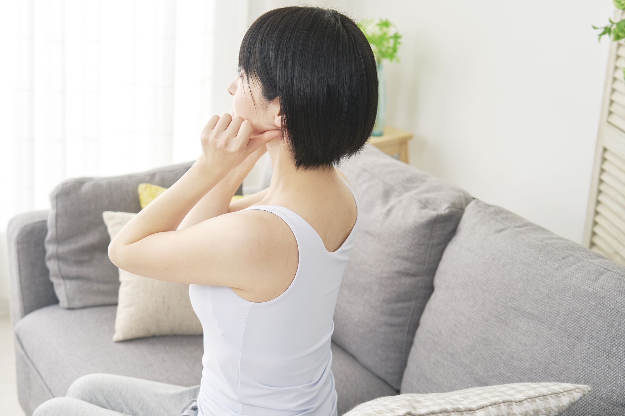 顎周りをマッサージする女性│瀬戸市で親知らず治療なら、瀬戸歯科